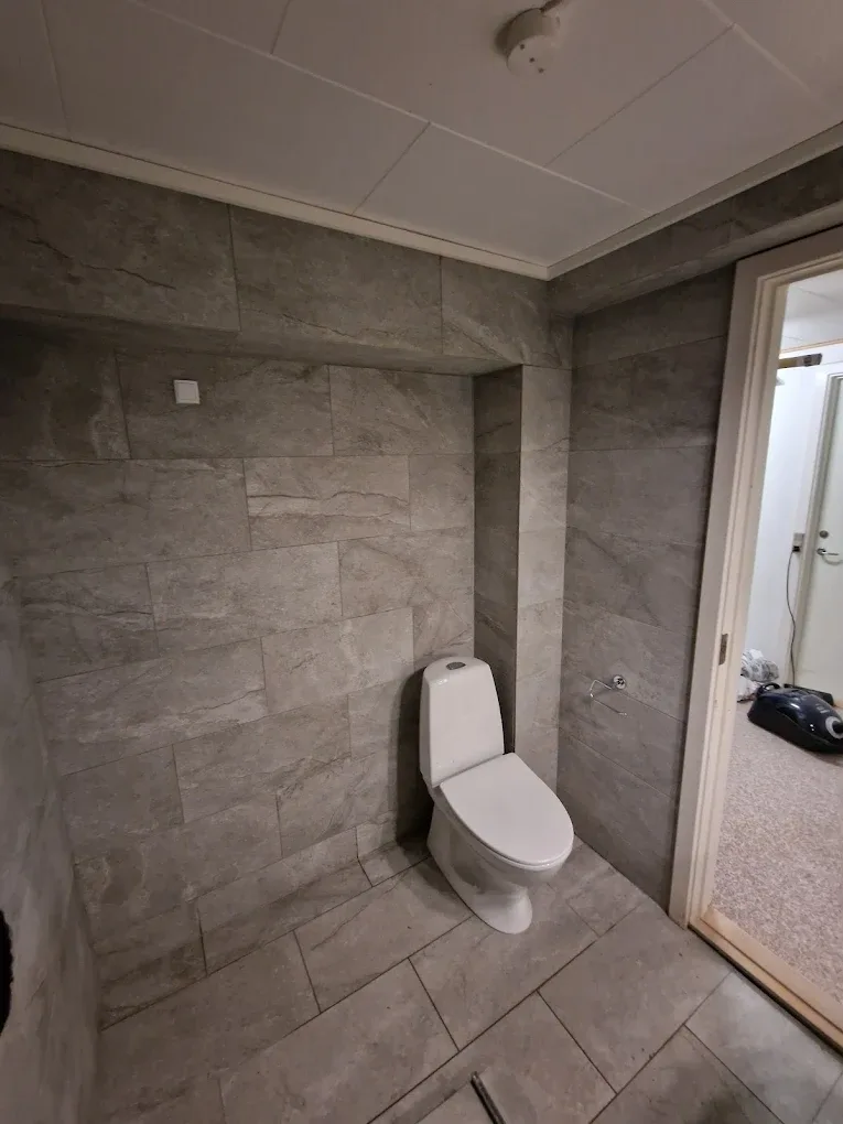 Badeværelse med grå fliser og toilet