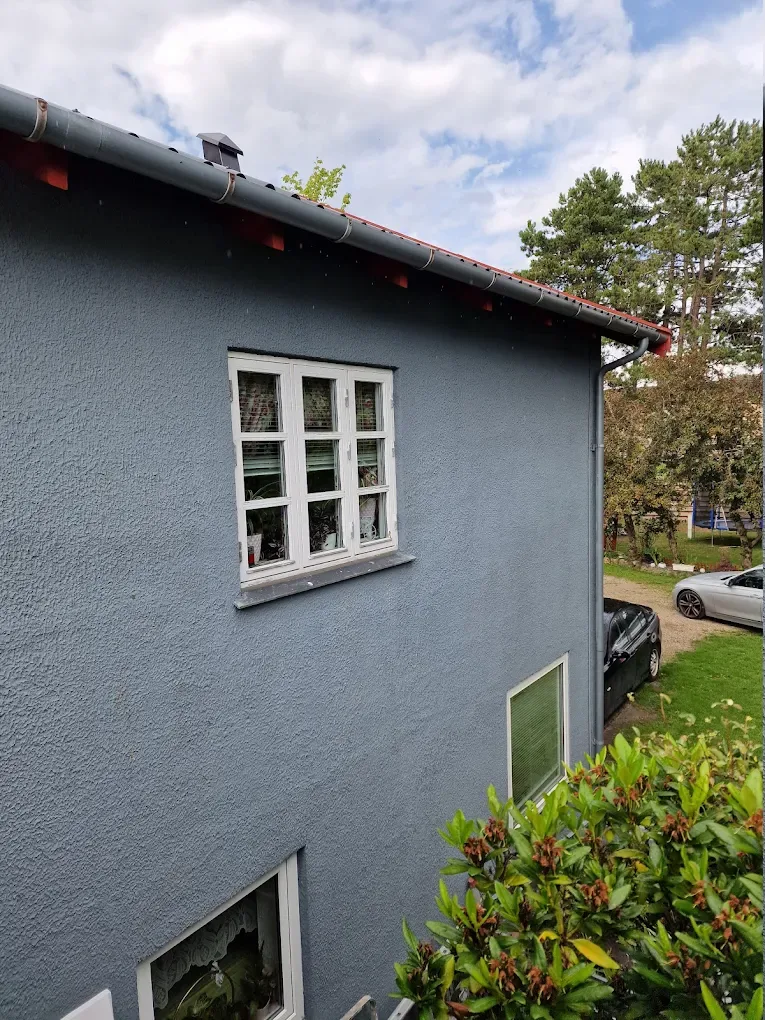 Hjørne af velholdt malet facade med hvide vinduer, samlet murer- og malerarbejde